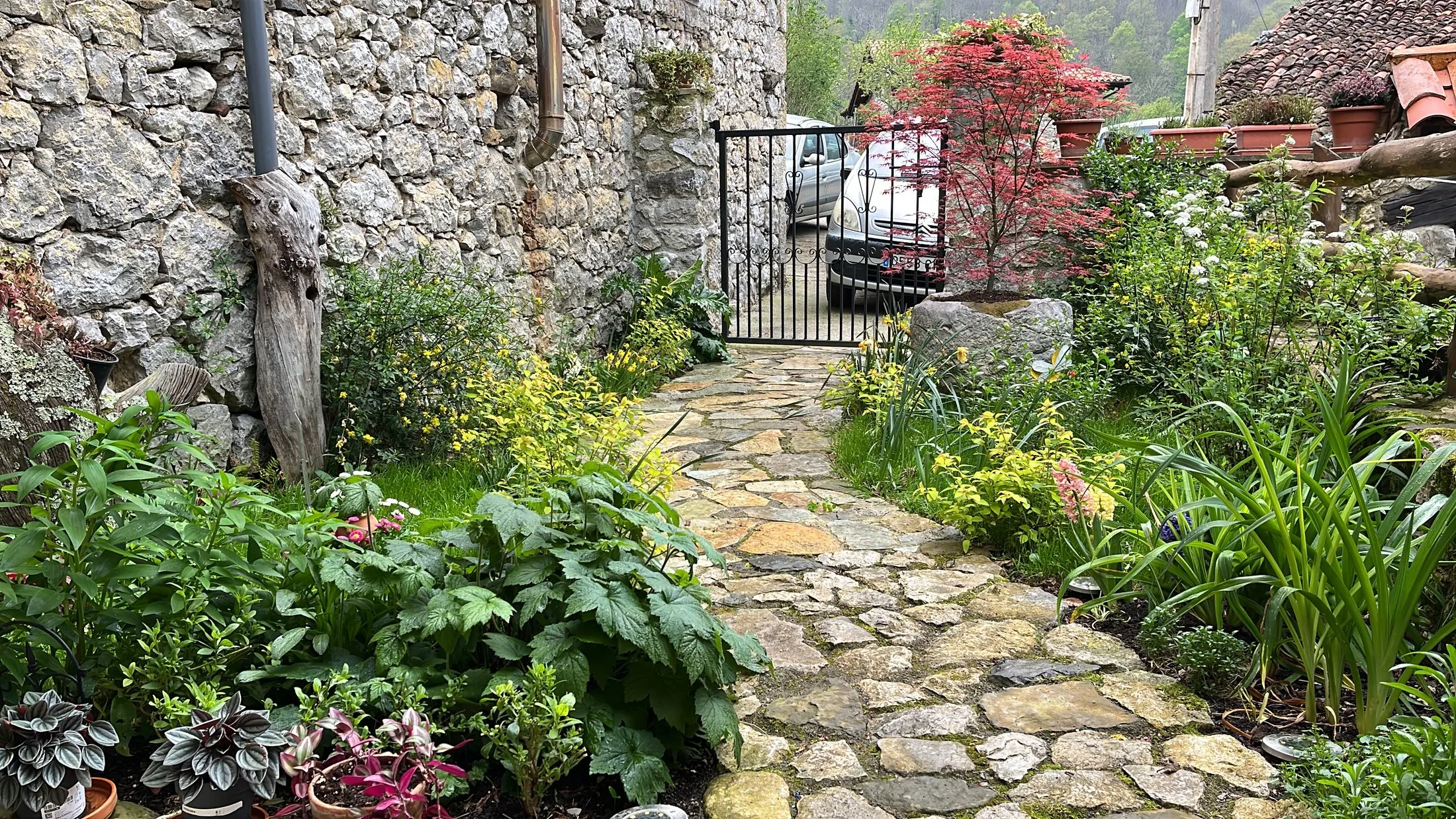 Fachada de piedra y jardín de la vivienda vacacional
