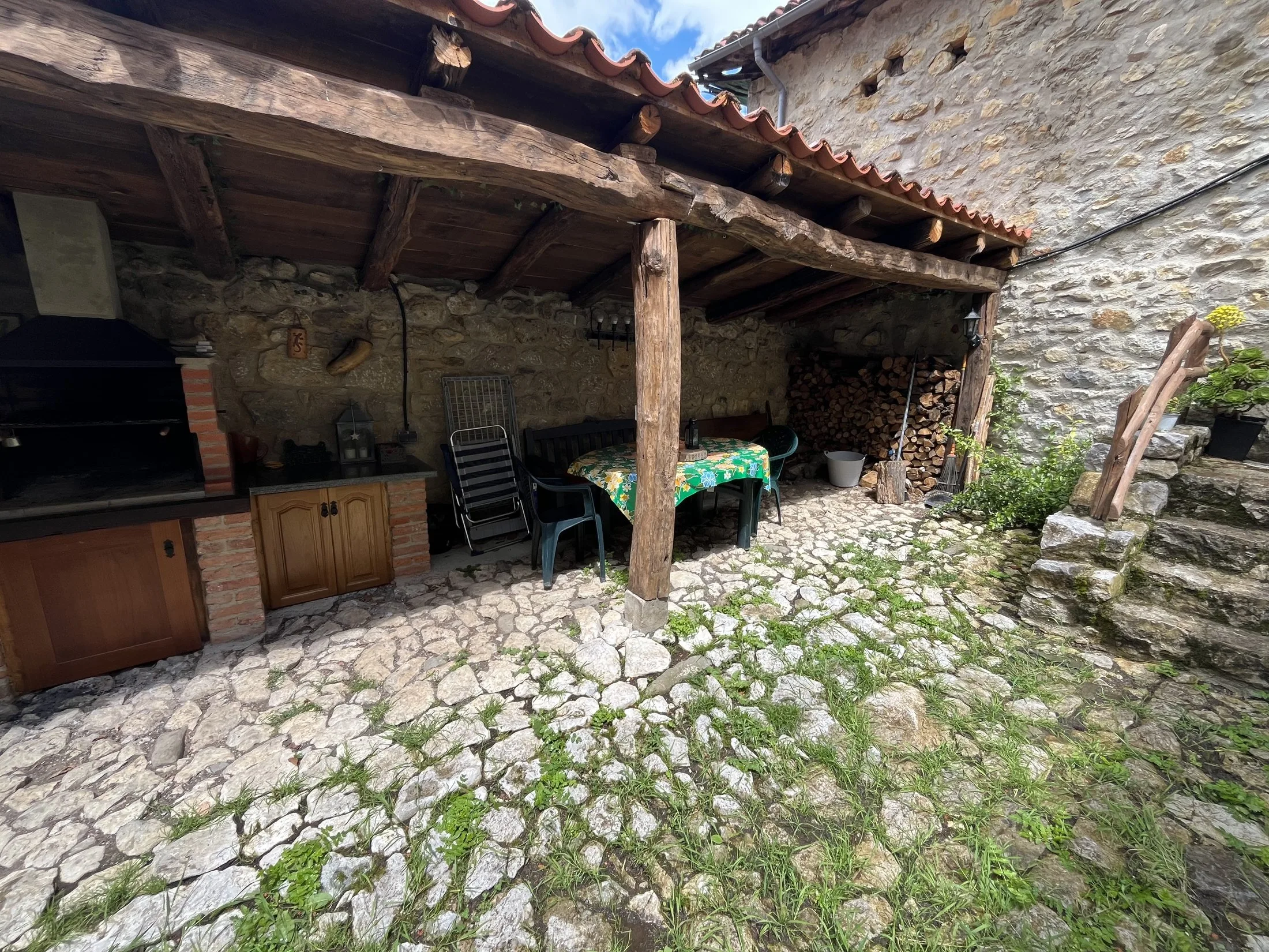Patio cubierto con muro de piedra tradicional